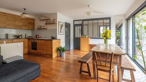 A modern kitchen with wooden cabinets, a dining area with a bench, and a large window with a view.
