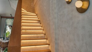 A modern staircase with integrated lighting, a concrete wall, and a minimalist design. - U Villas Pandawa (Kutuh)
