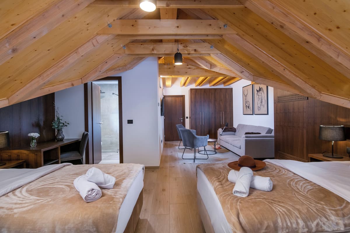 Un dormitorio estilo ático acogedor con dos camas, un escritorio y una zona de estar.