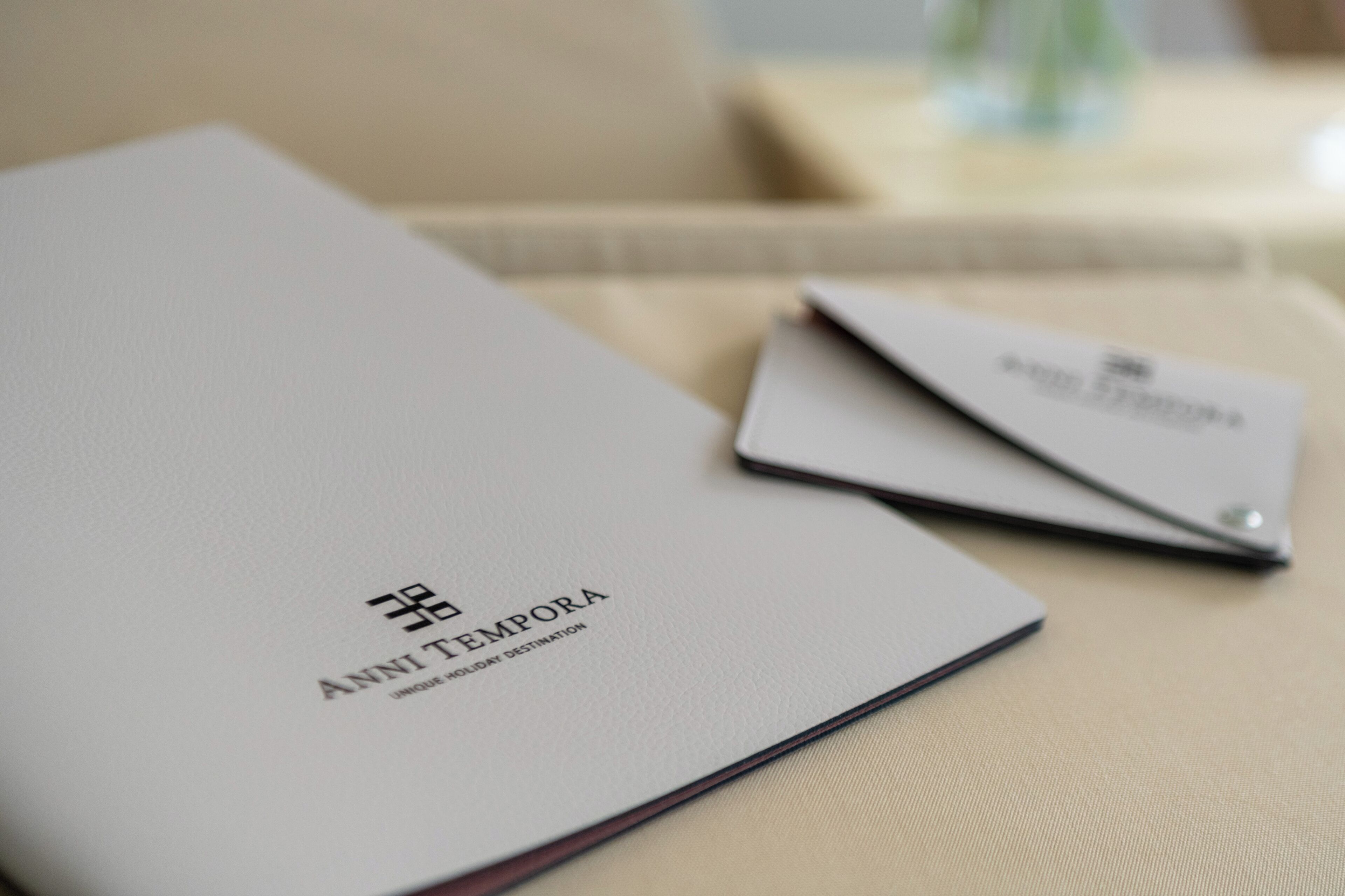 Une brochure intitulée « ANNI TEMPORA » est posée sur une table.