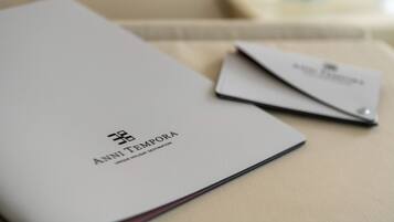 Une brochure intitulée « ANNI TEMPORA » est posée sur une table.