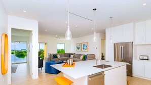 A modern kitchen with a central island, stainless steel appliances, and pendant lighting. - Luxury Waterfront 3bed Penthouse w/Rooftop Terrace (George Town)