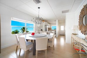 Enjoy meals in this elegant dining area with a round table and six chairs, surrounded by a stunning view of palm trees.