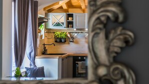 Une cuisine avec des poutres en bois, un meuble encastré, un évier et une plante.