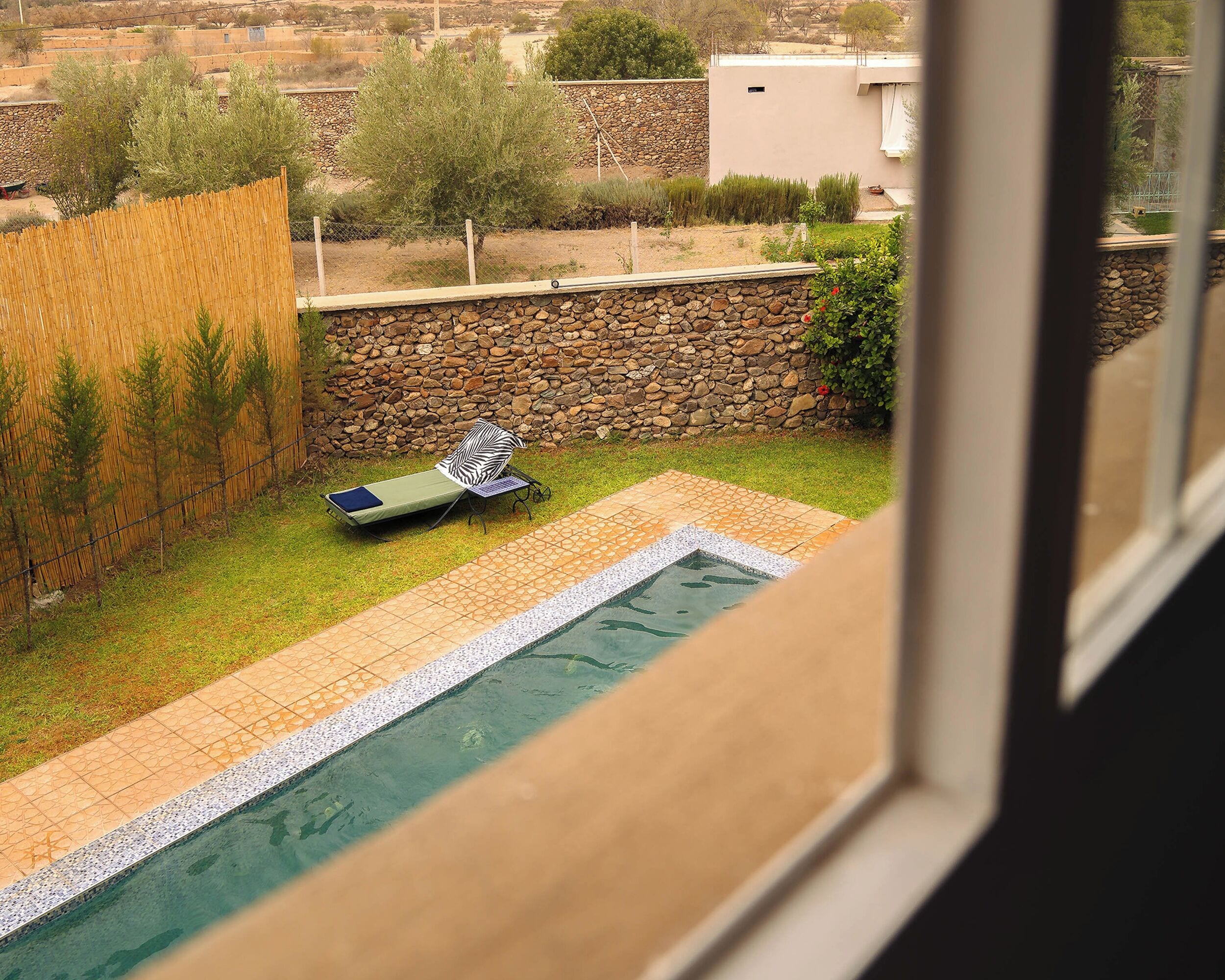 Un área de piscina con una silla de descanso y una piscina pequeña.