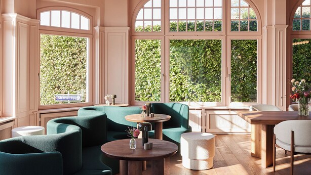 Une pièce spacieuse avec de grandes fenêtres, des canapés verts en tissu, une table ronde en bois et un pouf blanc.