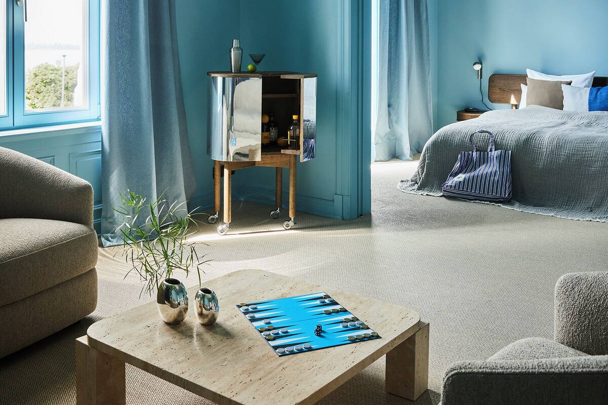 Een moderne slaapkamer met een bed, nachtkastje en een groot raam.