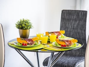 A table with a meal, including papaya, meat, and vegetables, and two glasses of orange juice.