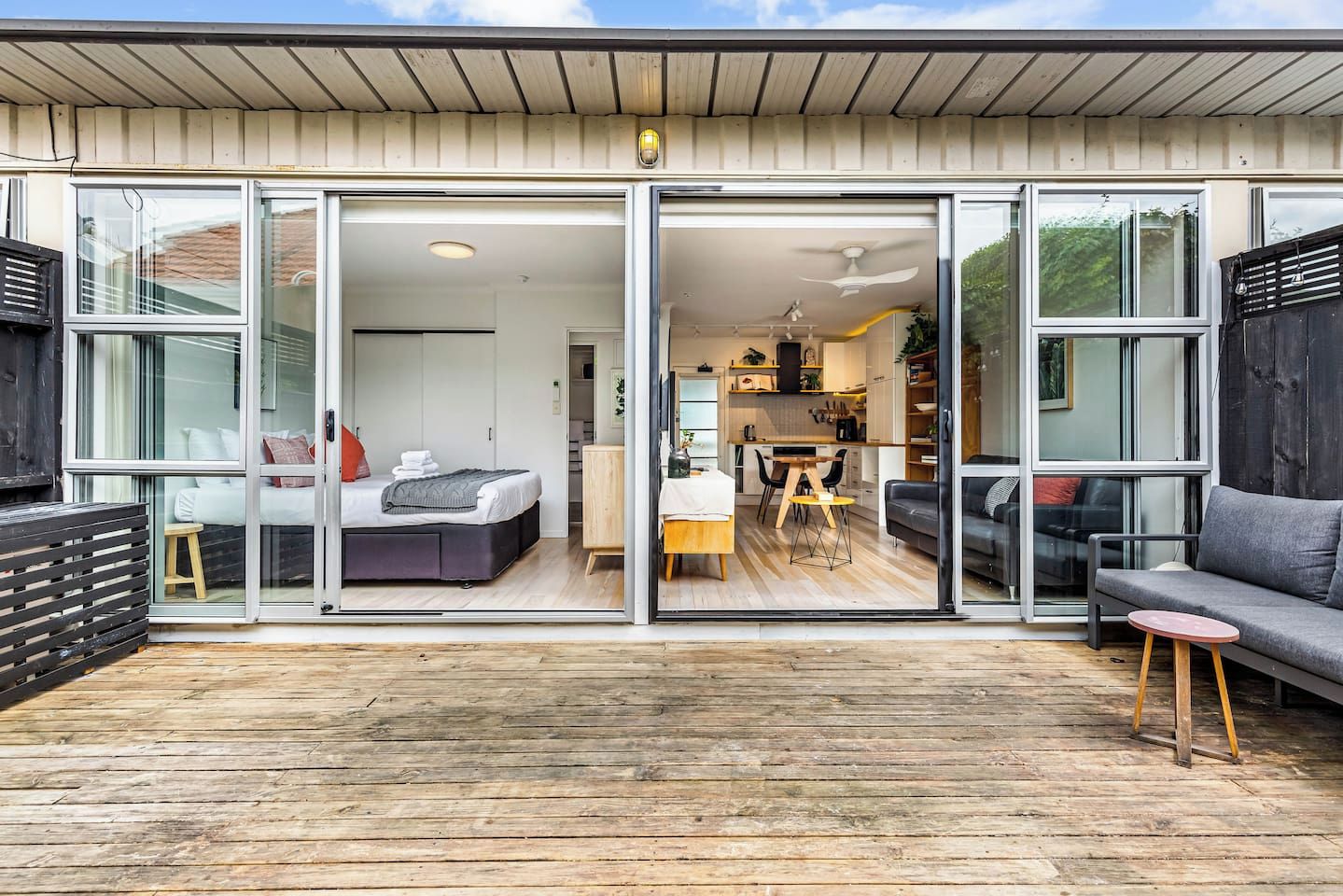 Une maison moderne dotée d’une grande porte-fenêtre coulissante qui donne accès à une chambre et à un coin repas.