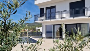 A modern two-story building with balconies, large windows, and a clear sky. - Villa V (Crikvenica)