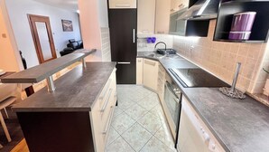 A modern kitchen with a dark countertop, a built-in dishwasher, and a stainless steel sink.