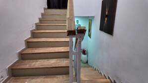 Eine Treppe mit Holzdielen und einem Metallgeländer, die zu einer Tür führt.