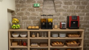 Ein Frühstücksbuffet mit verschiedenen Speisen und einer Kaffeemaschine.
