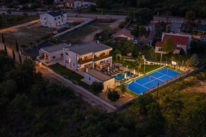 An aerial view of a residential area with modern houses, a swimming pool, and a tennis court. - Villa Quercus Zadarvillas (Policnik)