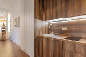 A modern kitchen with wooden cabinetry, a white countertop, and a built-in sink.