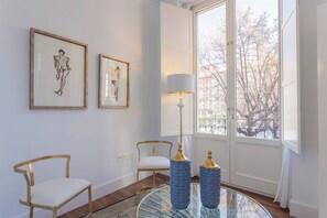 A room with two chairs, a table with a lamp, and two vases. - Luxury BibRambla Apartment (granada)