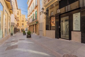 A narrow street lined with buildings, some with balconies and storefronts. - Luxury BibRambla Apartment (granada)