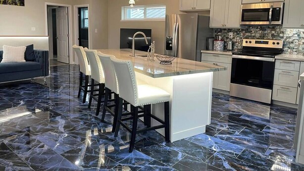 A modern kitchen with a marble floor, stainless steel appliances, and a central island with bar stools. - Luxury modern apartment (Willits)