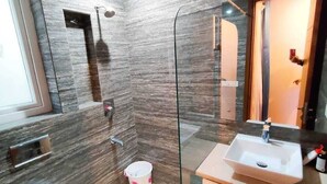 A modern bathroom with a glass shower enclosure, a white sink, and a toilet. - VINANDA (New Delhi)