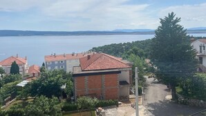 Et boligområde med huse, en vej og et vandareal i baggrunden.