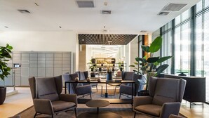 A modern lounge area with comfortable seating, a central table, and a view into a kitchen area. - Retreat in Providencia | Steps to Attractions (Providencia)