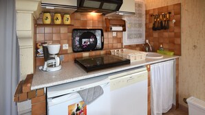 Une cuisine compacte équipée d’une machine à café, d’un grille-pain, d’un petit réfrigérateur et d’un évier.