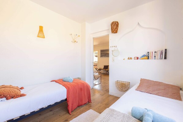 A bedroom with two beds, a bookshelf, and a doorway leading to another room. - Seaside house 2 terraces A/C parking (Valras-Plage)