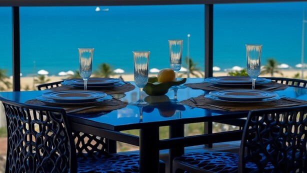 A table set for dining with a view of the ocean. - Beira Mar Fortaleza Landscape Luxo (Fortaleza)