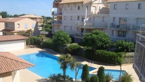 A residential building with a swimming pool surrounded by greenery. - T2 with Pool, Terrace & Parking (Valras-Plage)