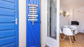 A blue door with a signpost indicating directions to the beach, ocean, and bar.