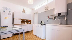 A modern kitchen with white cabinets, a dishwasher, a sink, and a countertop.