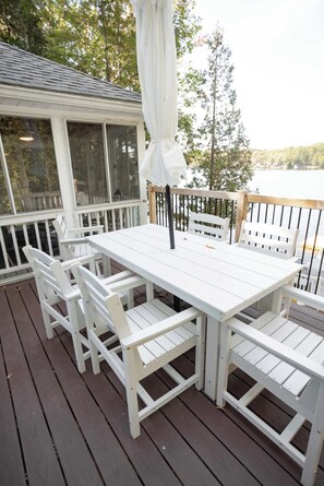 A white wooden deck with a table and chairs, overlooking a body of water. - Gables End Escape Lakefront Dock Kayaks (Belgrade)