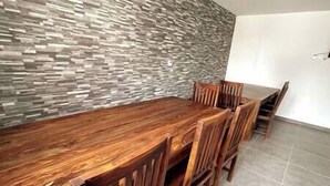 A dining area with a long wooden table and six wooden chairs.
