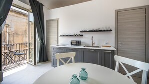 A modern kitchen with a dining area, a built-in radio, and a view of the outside. - Demetra - One Bedroom Apartment, Sleeps 4 (Noto)