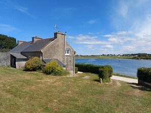 Situated by a calm body of water, this charming cottage offers a serene and atmosphere.