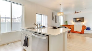 A modern kitchen with a dishwasher, a large window, and an island with a sink. - 4 Mi to Zions Bank Stadium: Sleek Herriman Retreat (Herriman)