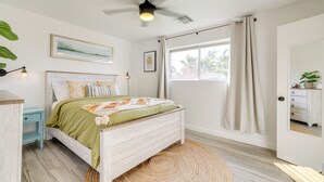 A bedroom with a bed, a ceiling fan, a window with curtains, a bedside table, and a wall-mounted artwork. - Families w/ Pets Welcome! Home 4 Mi to Dtwn Tempe (Tempe)