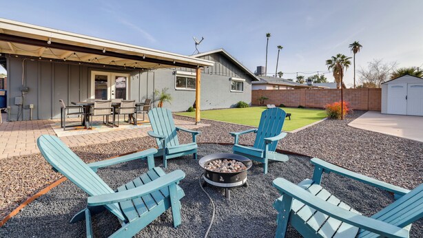 A patio area with four blue Adirondack chairs, a fire pit, and a covered seating area with a table and chairs. - Families w/ Pets Welcome! Home 4 Mi to Dtwn Tempe (Tempe)