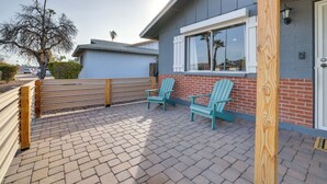 A patio with two Adirondack chairs, a wooden fence, and a brick pathway leading to a house with a window and a door. - Families w/ Pets Welcome! Home 4 Mi to Dtwn Tempe (Tempe)