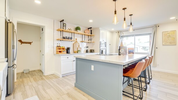 A modern kitchen with a central island, wooden shelves, and a large window. - Families w/ Pets Welcome! Home 4 Mi to Dtwn Tempe (Tempe)