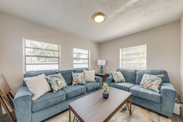 A living room with two sofas, a coffee table, and a lamp. - 1 Mi to Ocean: Home w/ Yard in Boynton Beach! (Boynton Beach)