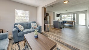 Un salon moderne avec un canapé, une table basse et une vue sur la cuisine.