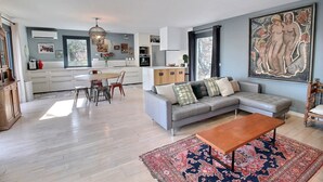 Un salon moderne avec un canapé gris, une table basse et un tapis à motifs.