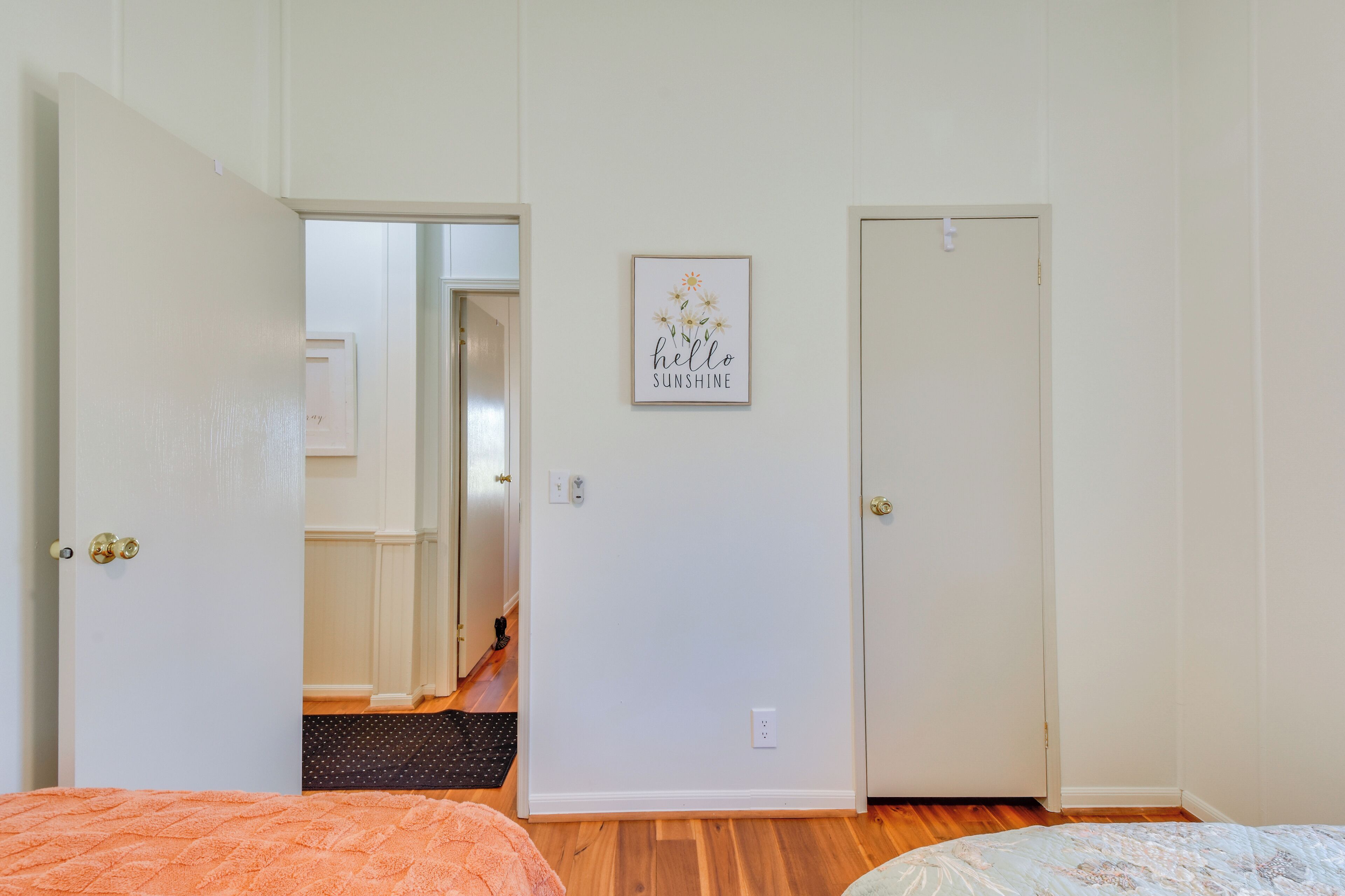 Un dormitorio con dos puertas, un pasillo y un cartel en la pared.