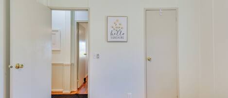 Un dormitorio con dos puertas, un pasillo y un cartel en la pared.