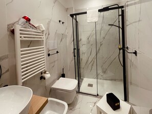 Een douche, een haardroger, een bidet, handdoeken