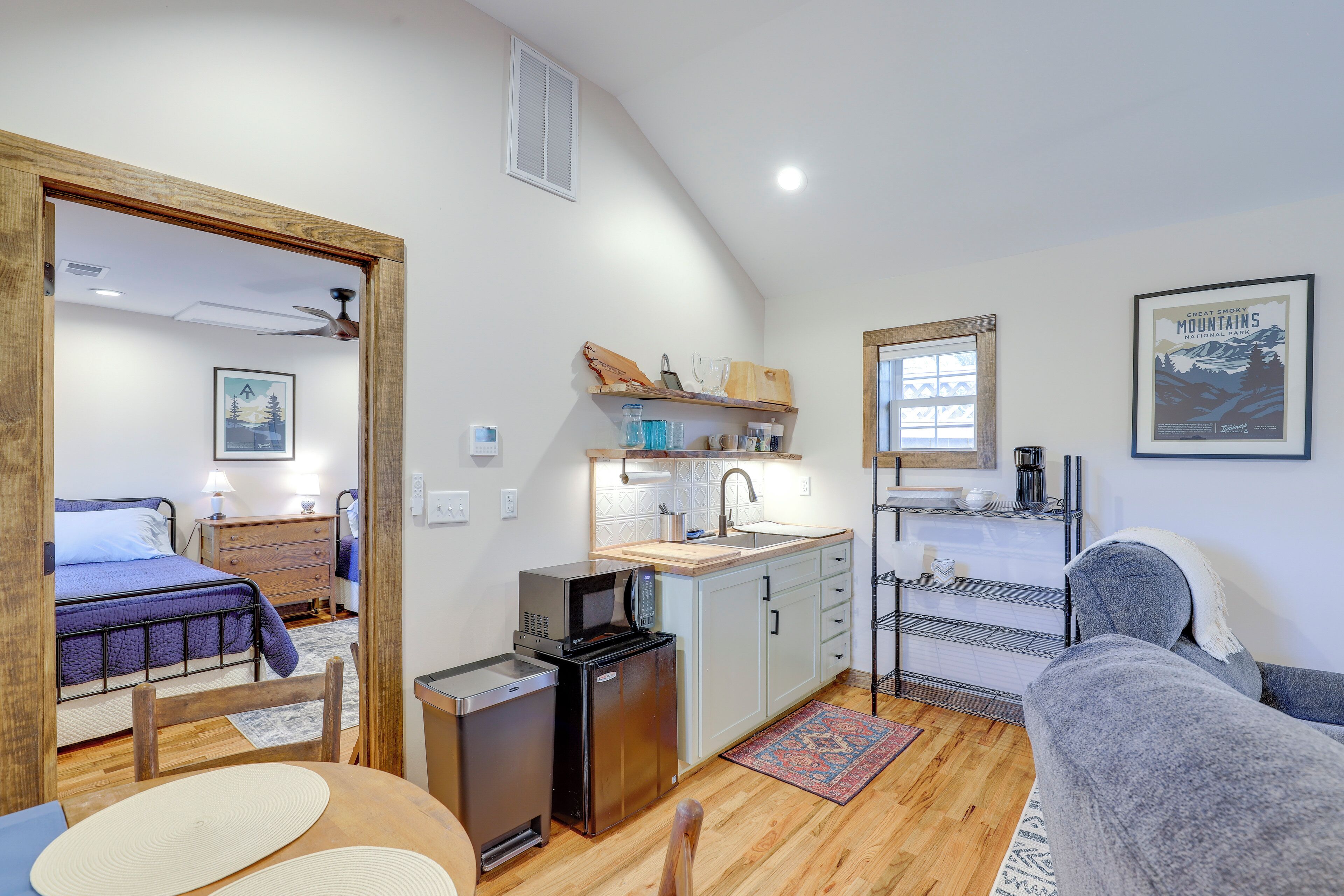 A compact living space with a kitchenette, a bed, and a seating area.