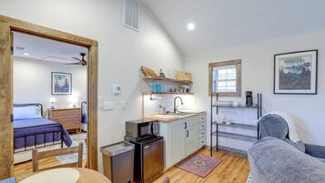 A compact living space with a kitchenette, a bed, and a seating area.