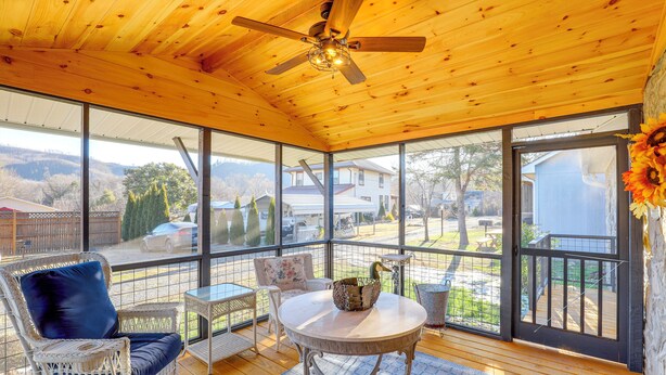 A covered patio with wicker furniture, a ceiling fan, and large windows offering a view of the backyard. - Walk to Appalachian Trail: Hot Springs Hideaway (Hot Springs)
