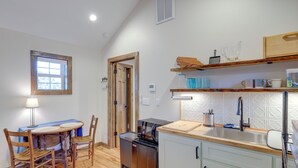 A compact kitchen with wooden cabinets, a built-in oven, a sink, and a dining area with a table and chairs. - Walk to Appalachian Trail: Hot Springs Hideaway (Hot Springs)